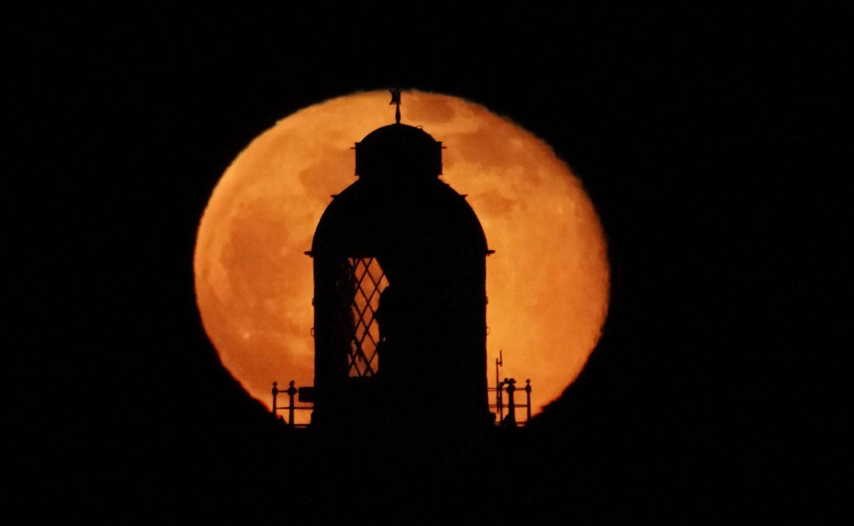 The moon rising at the top of St Mary’s Lighthouse in Whitley Bay, Northumberland (Owen Humphreys/PA)