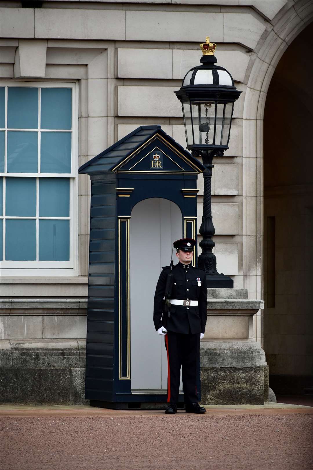 A soldier from 34 Fd Sqn in a sentry box guarding Buckingham Palace.