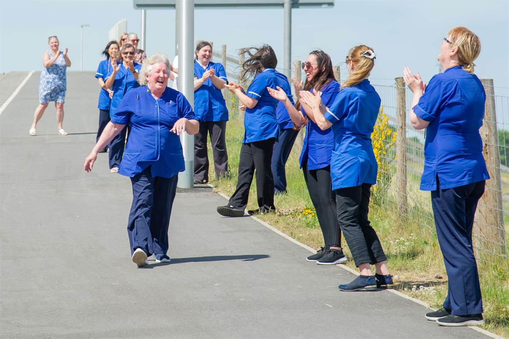 Forres carer Janette Smithies receives a clap from her colleagues on the Waterford bridge as she retires from her role of 15 years.