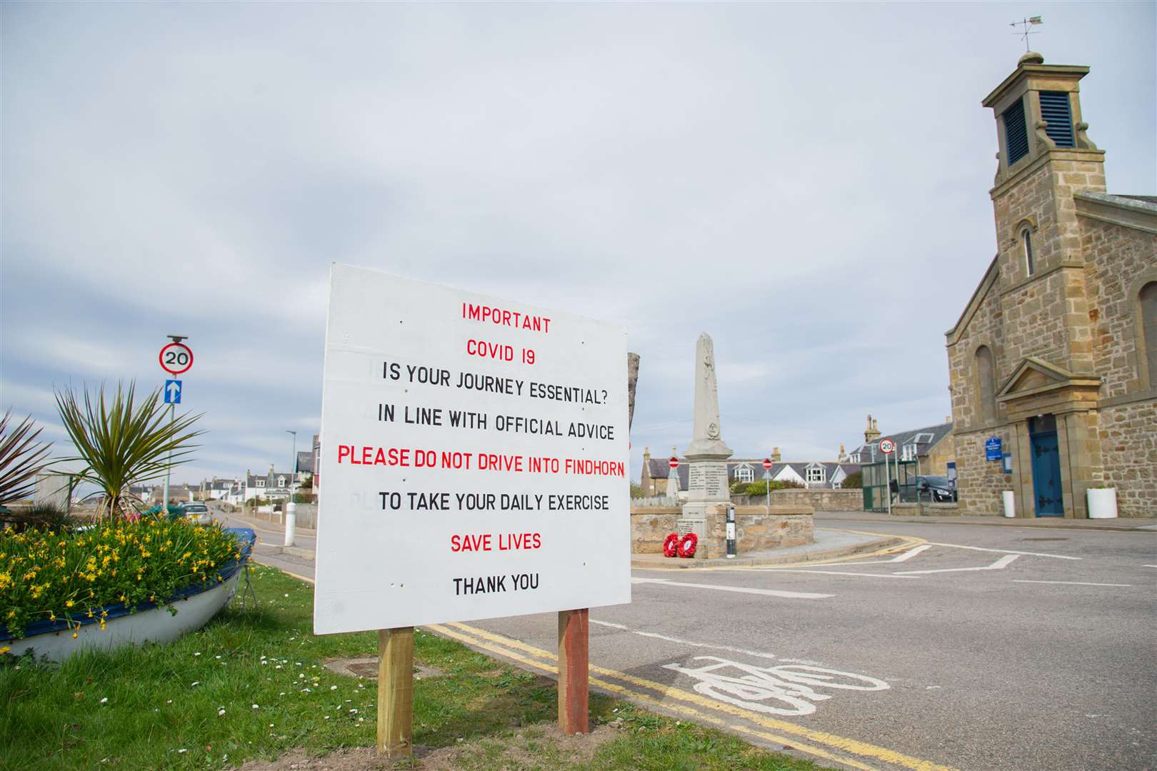 The sign at the entrance to the village centre warning against unnecessary travel before it was vandalised.