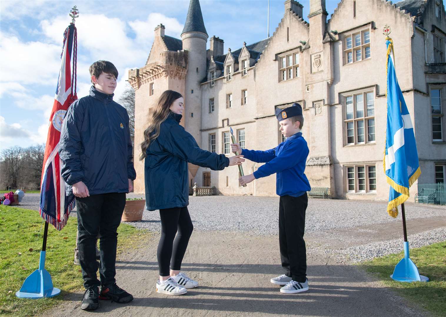 Jack Coulby (right) hands the baton over to Kayleigh MacColl at Brodie Castle. The baton arrived at Grant Park by a fire engine.