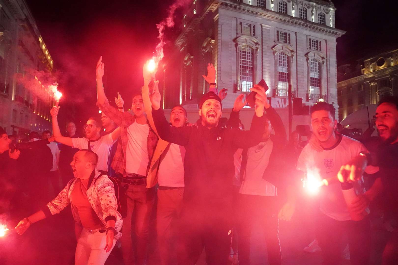 Fans let off flares as they celebrate England’s extra-time win over Denmark in Piccadilly Circus, central London, on Wednesday night (Kirsty O’Connor/PA)