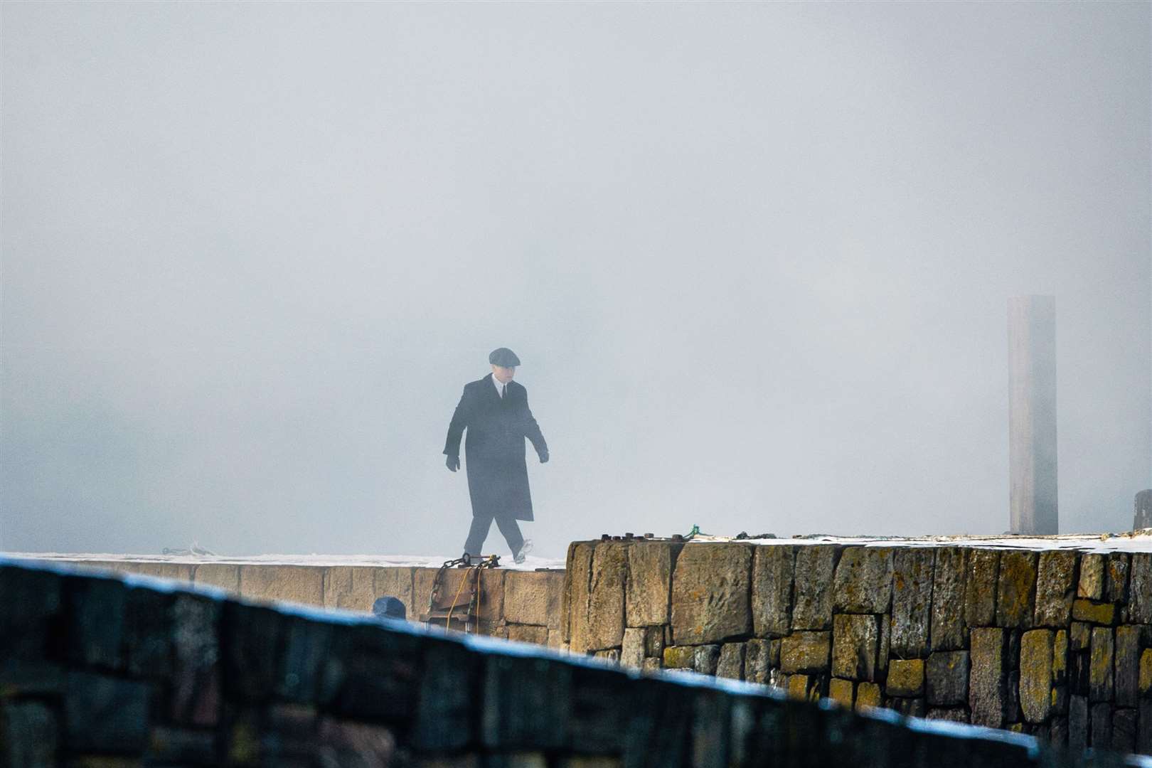 Tommy Shelby, who is played by Cillian Murphy, walks along Portsoy's old harbour pier through artificial smoke during filming.Picture: Daniel Forsyth