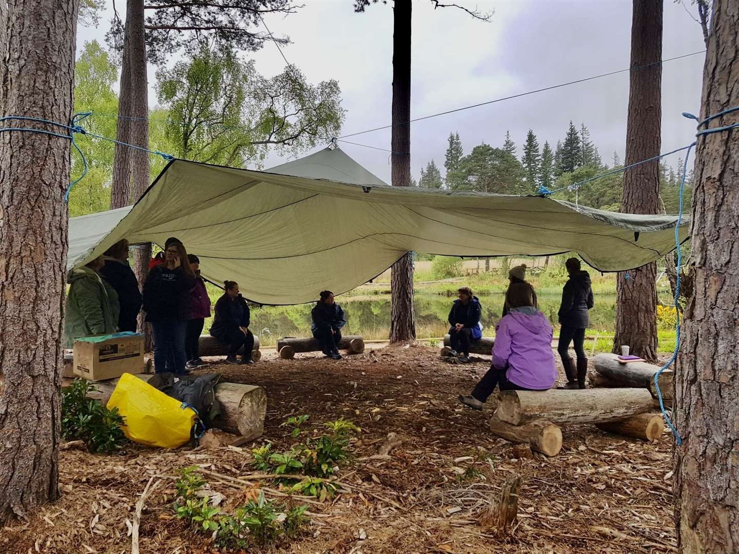Demonstrating how to put up tarp for an outdoor classroom.