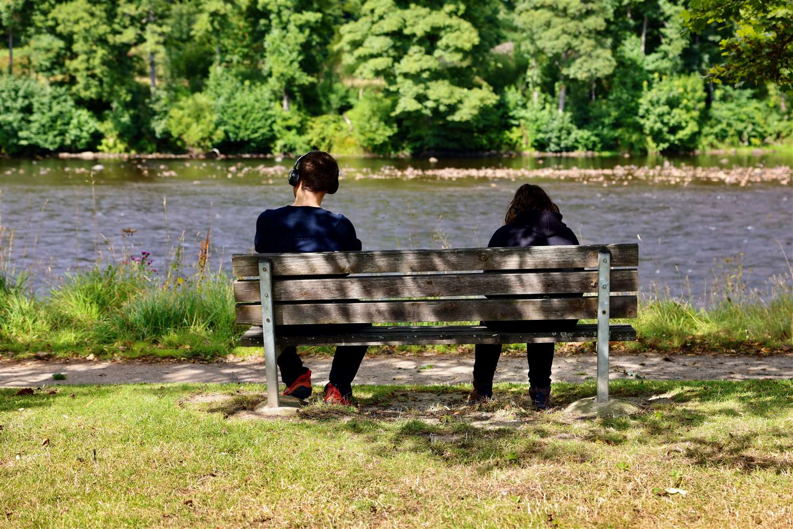 A couple on a bench by the River Spey in Aberlour.