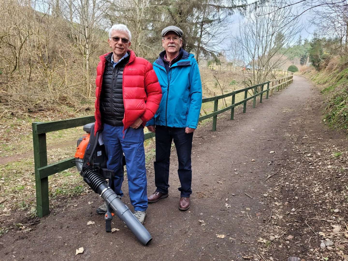 Dava Way Association secretary Malcolm Campbell and chairman Neil Sinclair with their new leaf blower at the new fence on Mannachie Avenue.