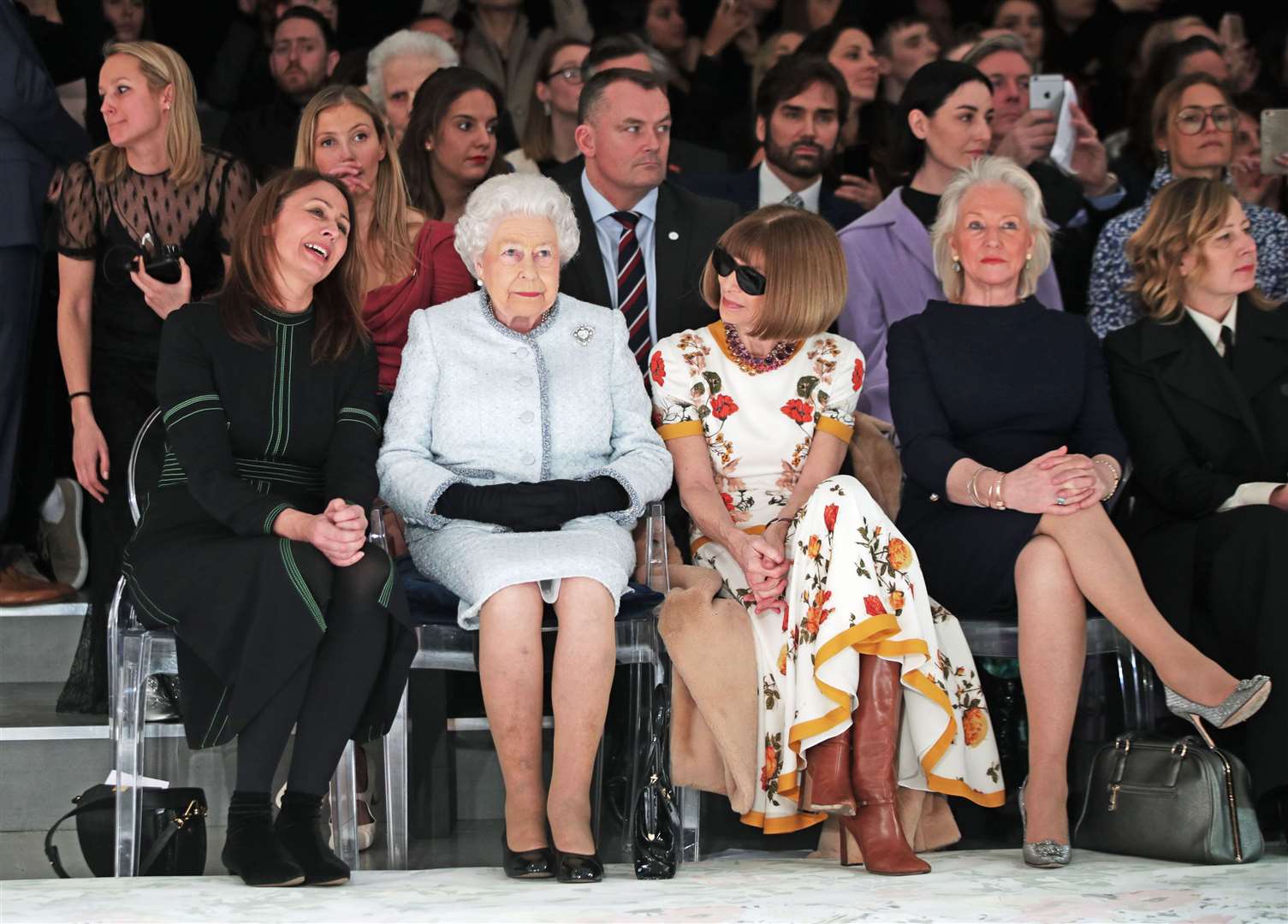 The Queen sits with Dame Anna Wintour, Caroline Rush and Angela Kelly (second right) during a fashion show (Yui Mok/PA)