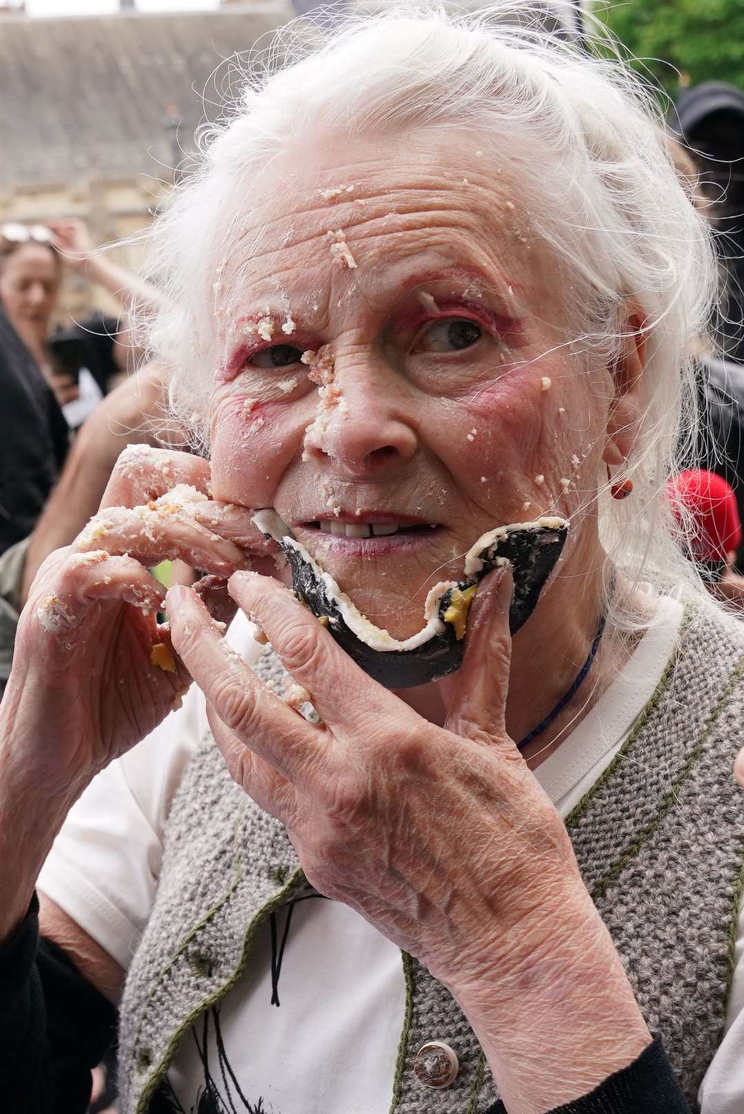 Dame Vivienne smears cake on her face as she joins supporters of Wikileaks founder Julian Assange for a picnic in Parliament Square in 2021 (Jonathan Brady/PA)