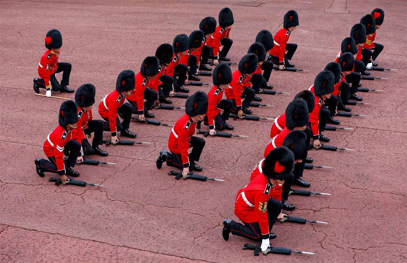 Members of the Coldstream guards kneel and place their rifles on the ground before cheering as the Principal Proclamation is read (Richard Heathcote/PA)