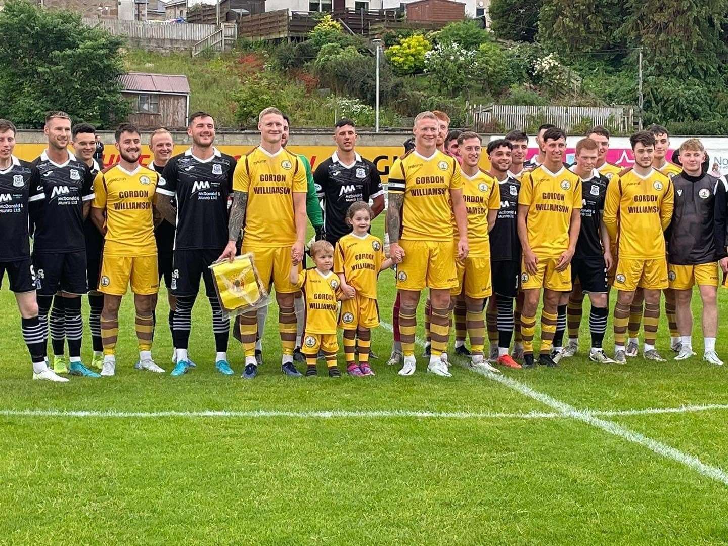 The Fraser twins line up with the Forres Mechanics and Elgin City players before kick off. Photo: Forres Mechanics Facebook.