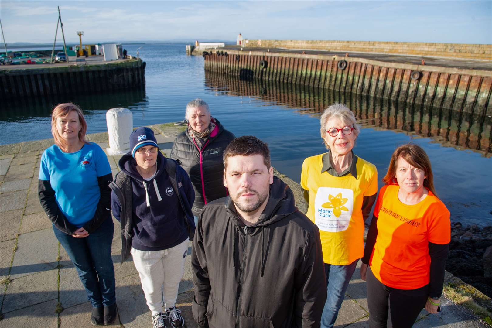 Jamie Campbell, the Burghead Boxing Day Swim's president, is joined by commitee members and representitives from this years chosen charities. Photo taken before lockdown. Picture: Daniel Forsyth