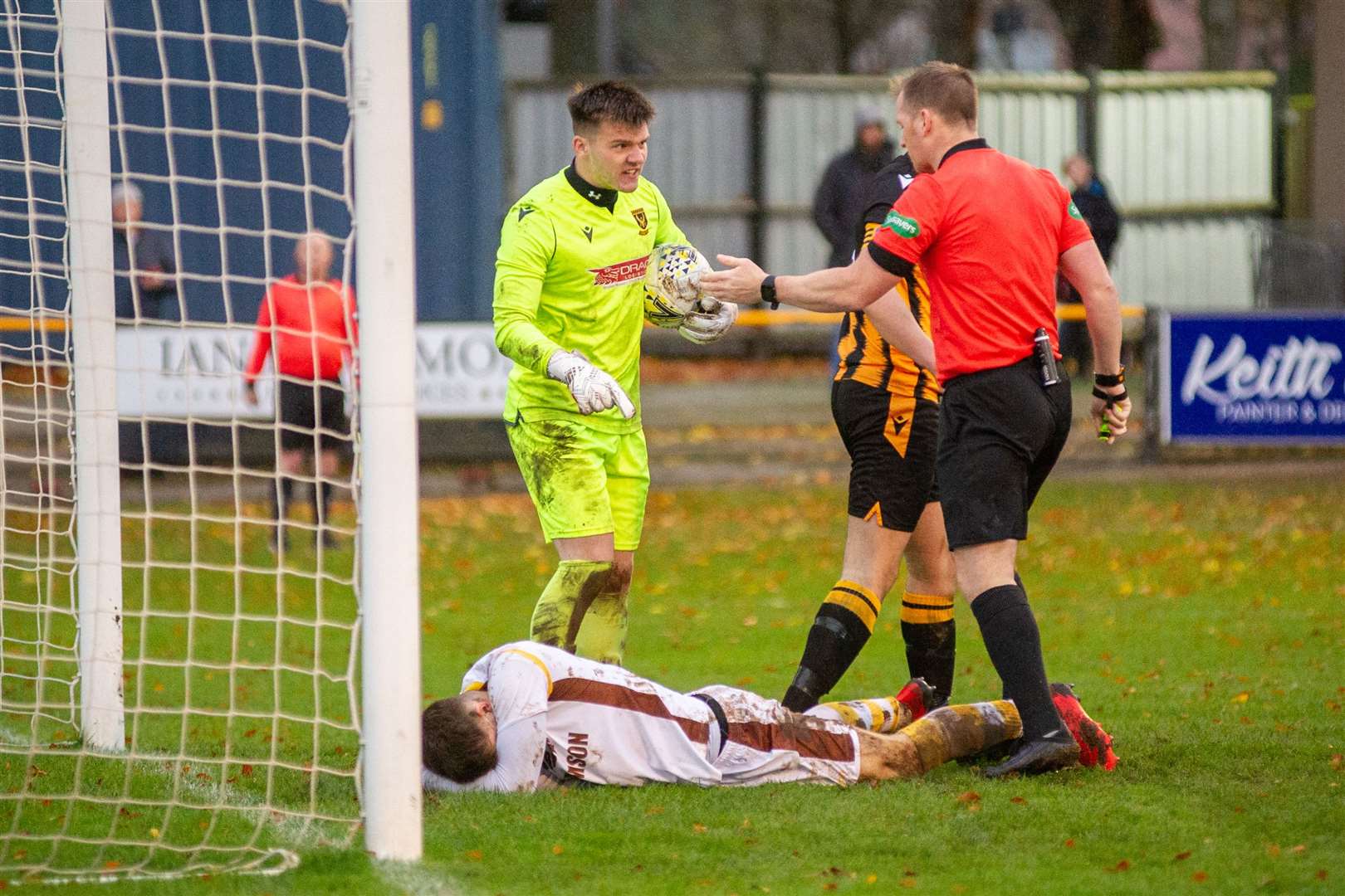 Huntly goalkeeper Tom Ritchie has words with referee Chris Fordyce over Forres' Jack Grant's challenge. Picture: Daniel Forsyth..