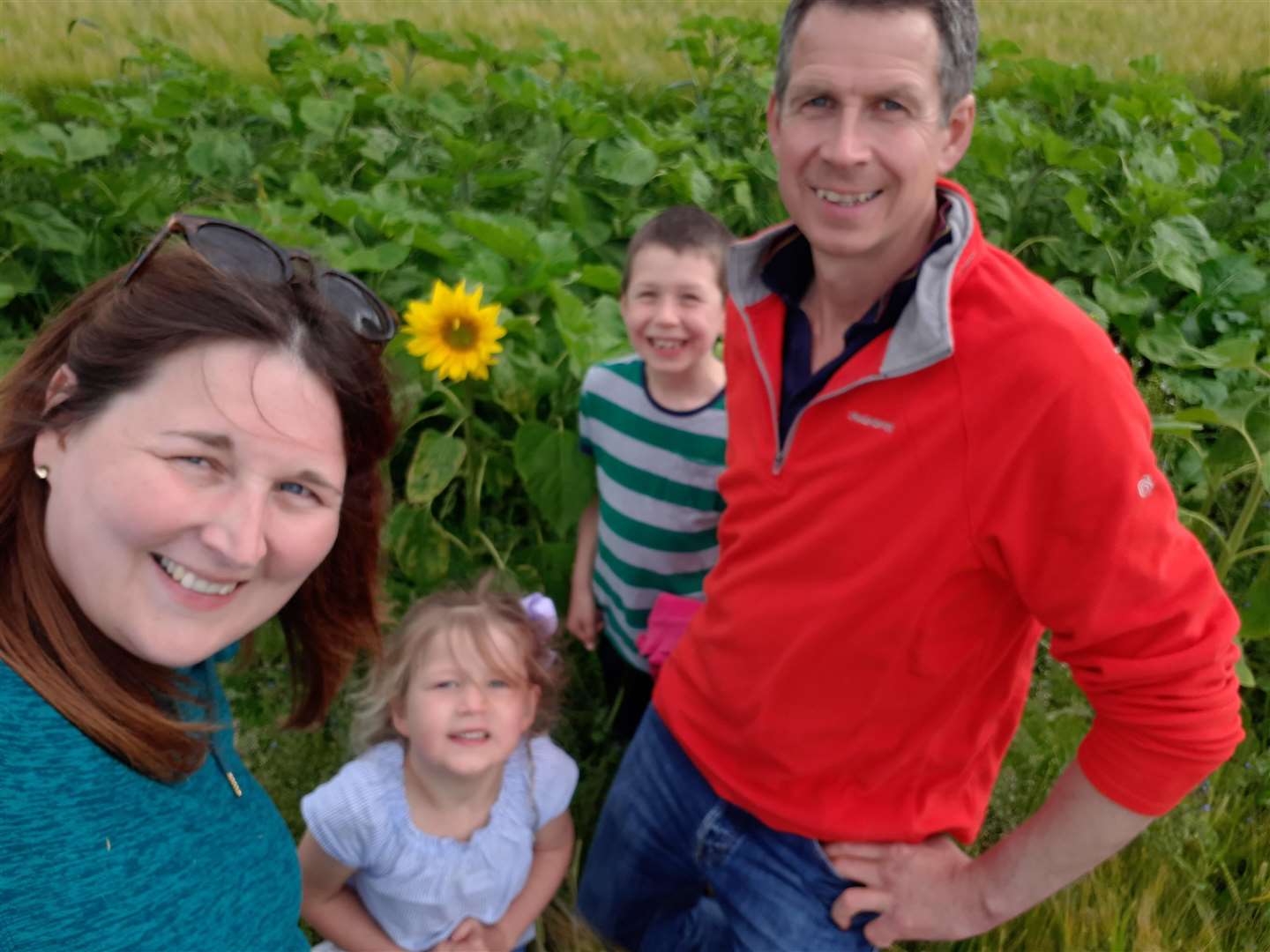 Byres Farm owners Bill and Helen Smith and their children, Marshall and Louisa, with the first sunflower of the crop to bloom.