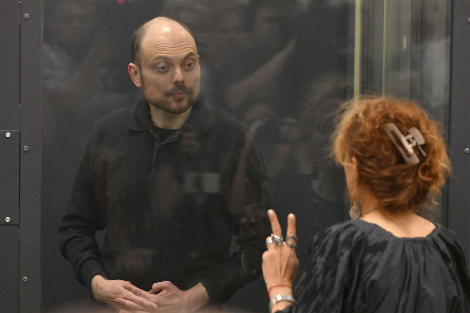 Vladimir Kara-Murza speaks to his lawyer while standing in a glass cage in a courtroom in Moscow (Dmitry Serebryakov/AP)
