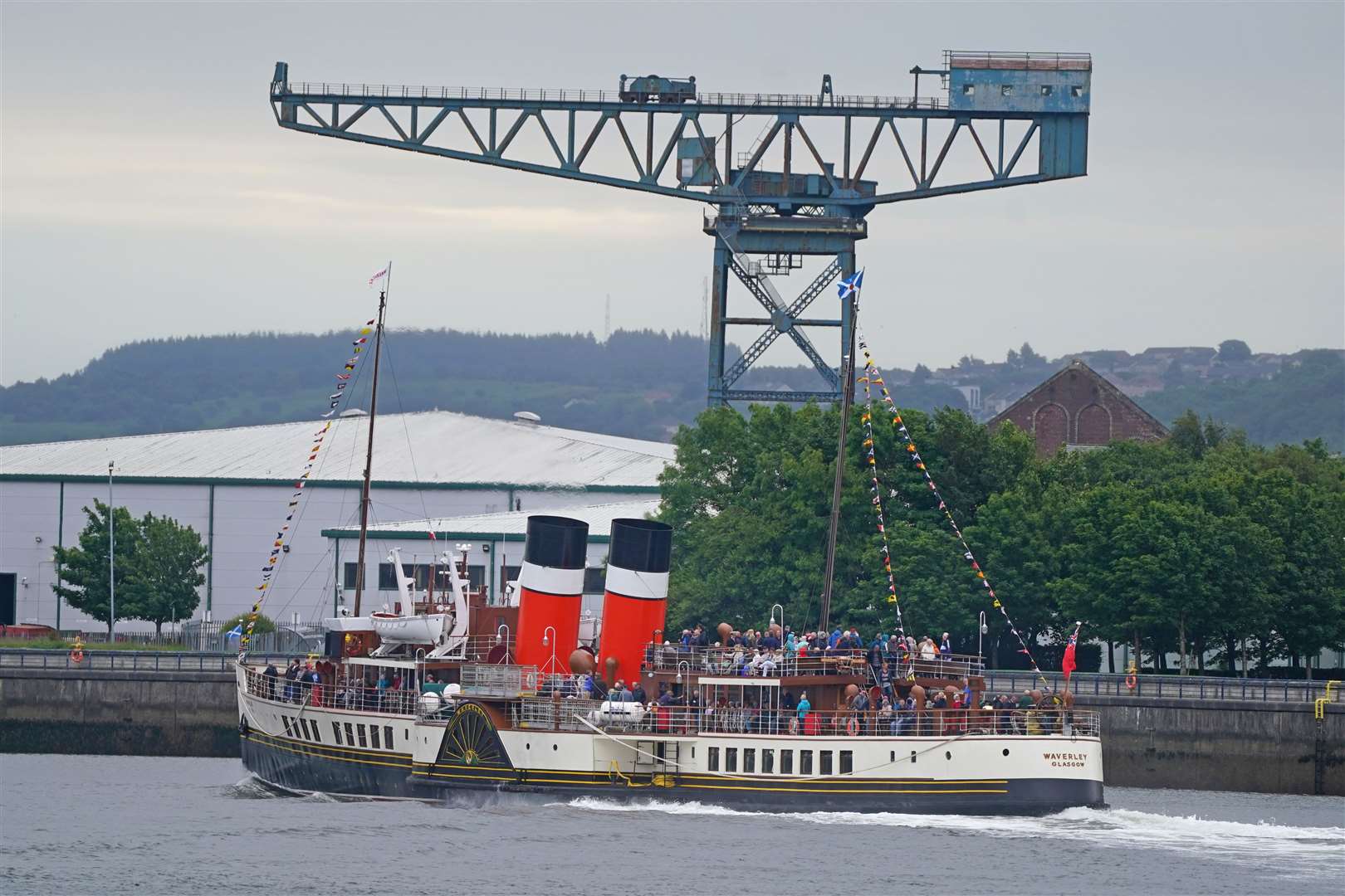The paddle steamer Waverley celebrated the 75th anniversary of its maiden voyage as it cruised past Clydebank’s Titan crane in June (Andrew Milligan/PA Wire)