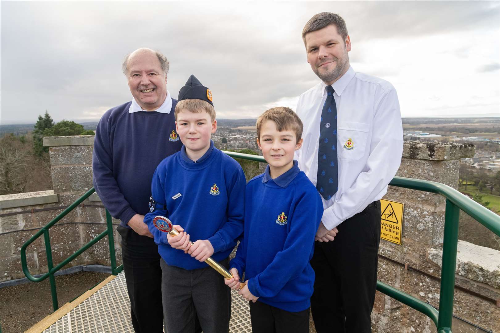 Jamie Campbell and Reece MacInnes of Burghead (right) hand over the Kings Baton to Graeme Ferguson and Elliot Wilson of Forres at the top of Nelson’s Tower.