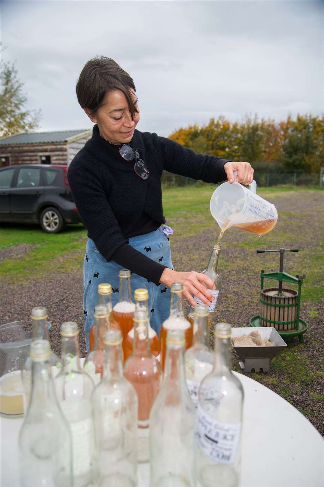 Kelly Warren pouring juice into bottles ready to be sold.
