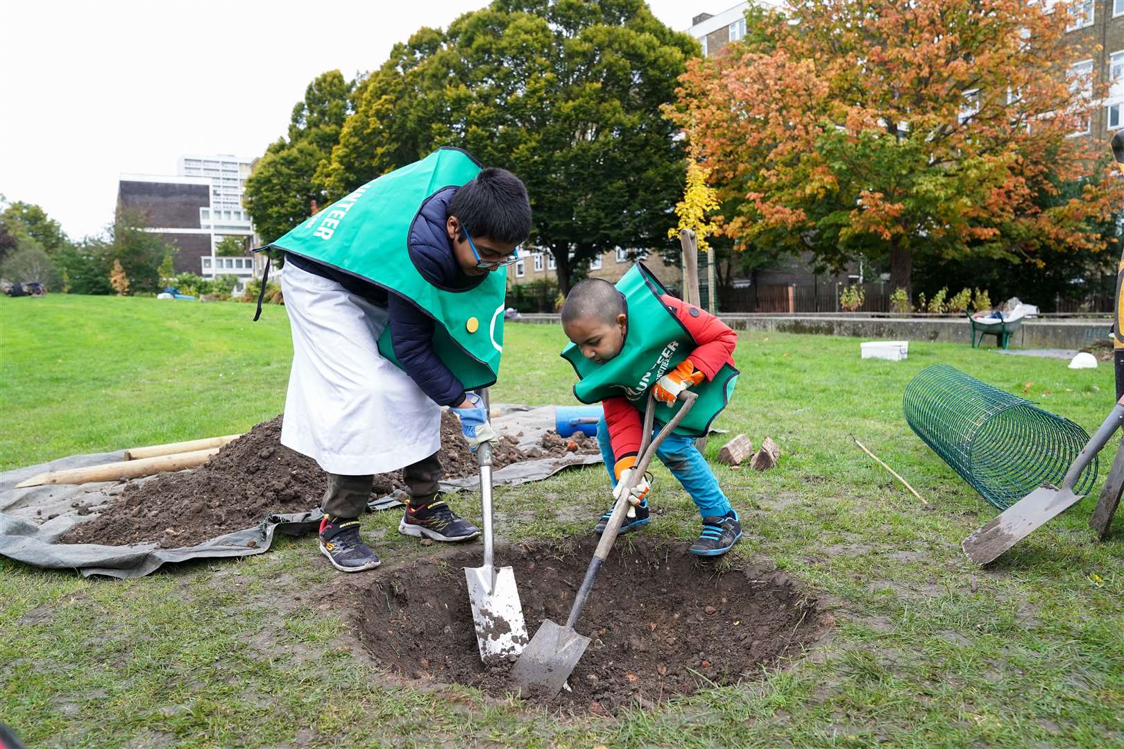 Ahmed Khan, eight, (left) and his brother Ammar Khan, four, help plant a tree (Kirsty O’Connor/PA)