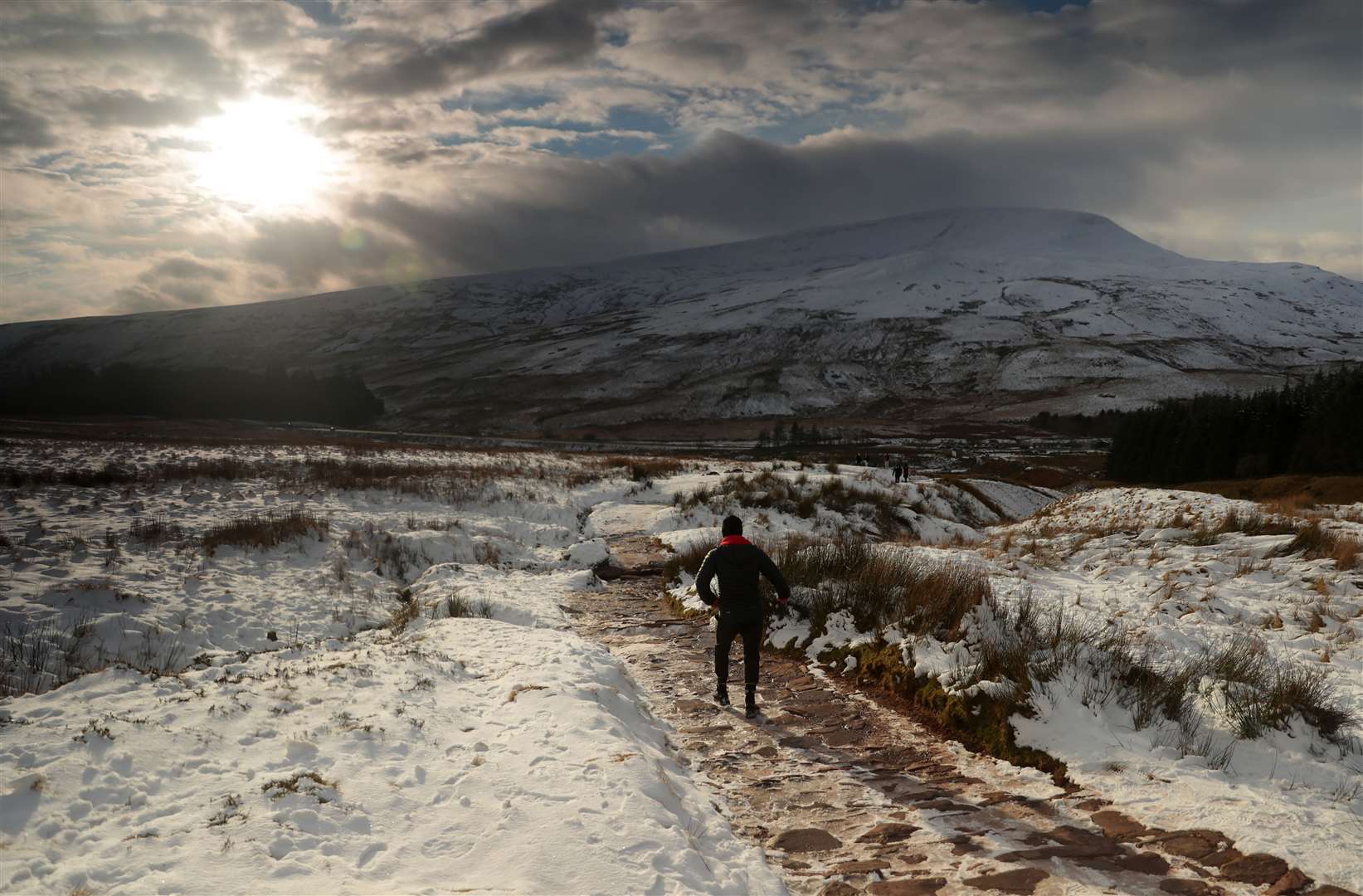 People walk a snowy path in the Brecon Beacons, South Wales (David Davies/PA)
