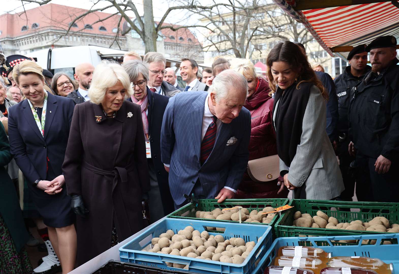 The King and Queen Consort and Berlin’s governing mayor Franziska Giffey (far left) take a closer look at the produce on sale (Adrian Dennis/PA)