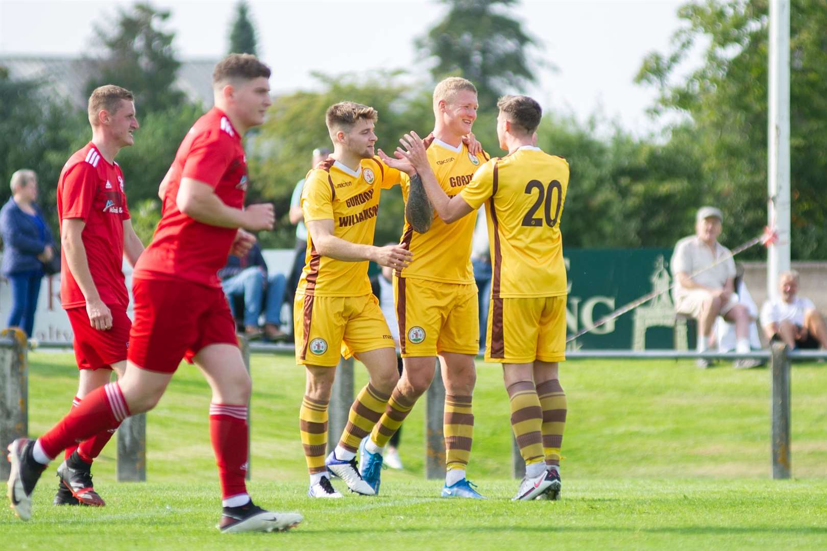 Forres frontman Lee Fraser celebrates with teammate Jack Grant and Dale Wood after he scored the only goal of the afternoon. ..Forres Mechanics FC (1) vs Lossiemouth FC (0) - Highland Football League - Mosset Park, Forres 28/08/2021...Picture: Daniel Forsyth..