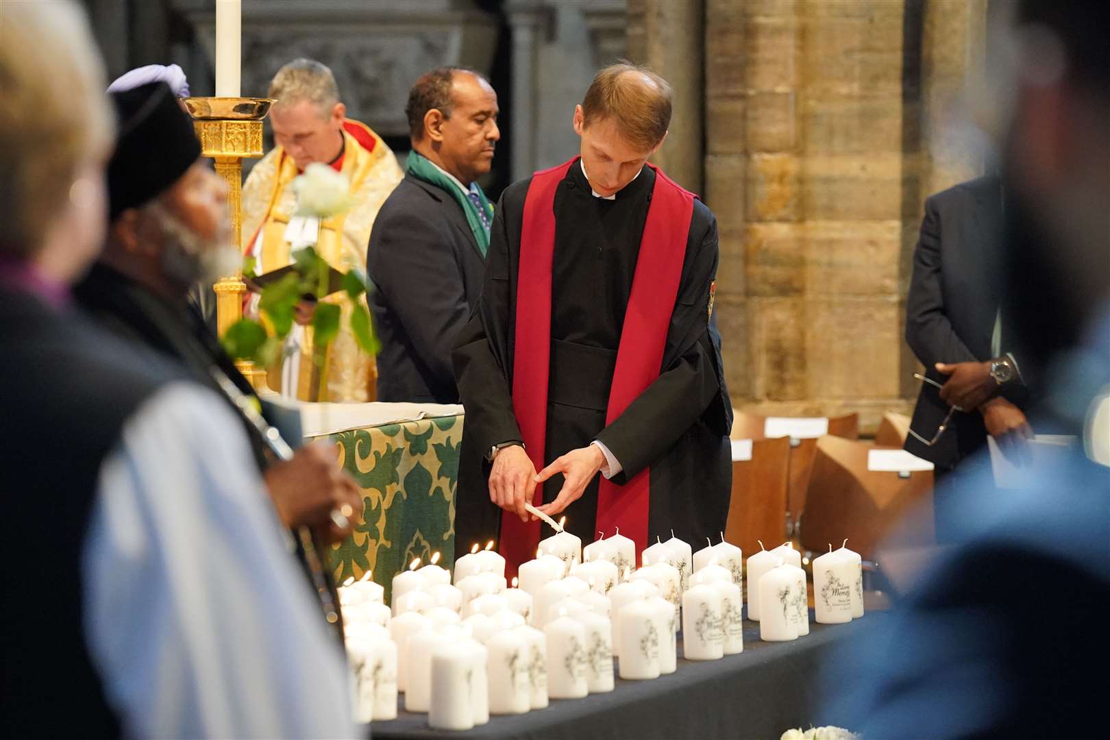A member of the clergy lights candles with the names of the Grenfell victims on them (Jonathan Brady/PA)