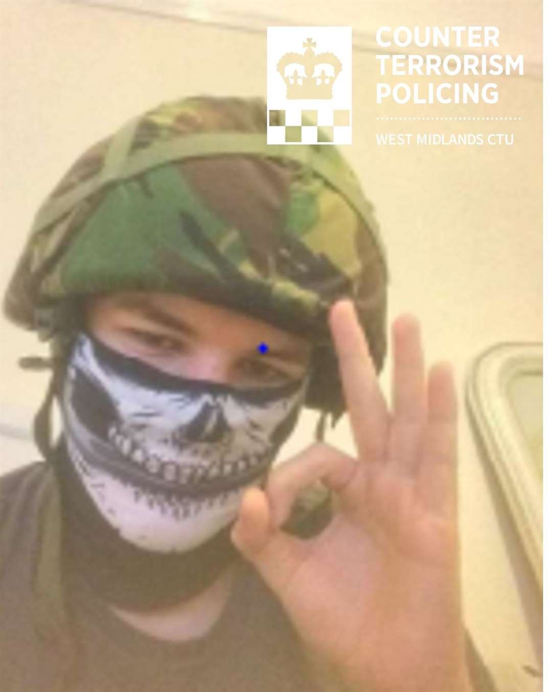 Vaughan Dolphin wearing an army helmet, wearing a skull mask, and making the ‘okay’ hand gesture – which is linked to the white supremacist movement (West Midlands Police/PA)