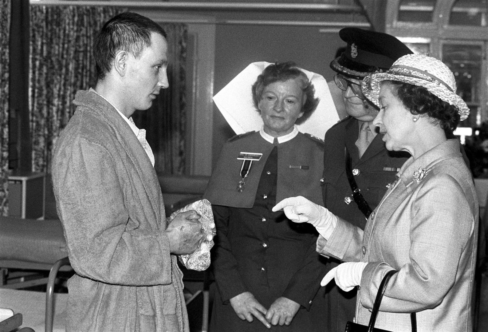 The Queen talking with Lance Sgt Graham Evans, of the Welsh Guards, when she visited the wounded from the Falklands at the Cambridge Military Hospital at Aldershot (Ron Bell/PA)
