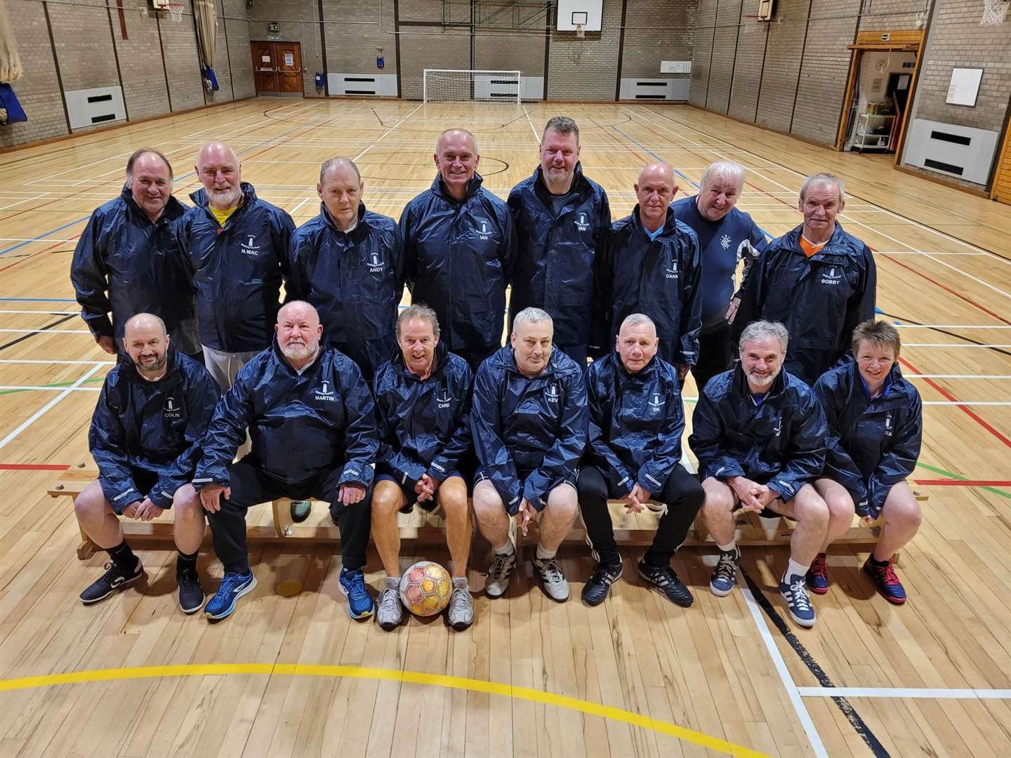 Forres’ walking footballers in new coach jackets featuring a Nelson’s Tower team logo designed and supplied by H&M Designs, Elgin.