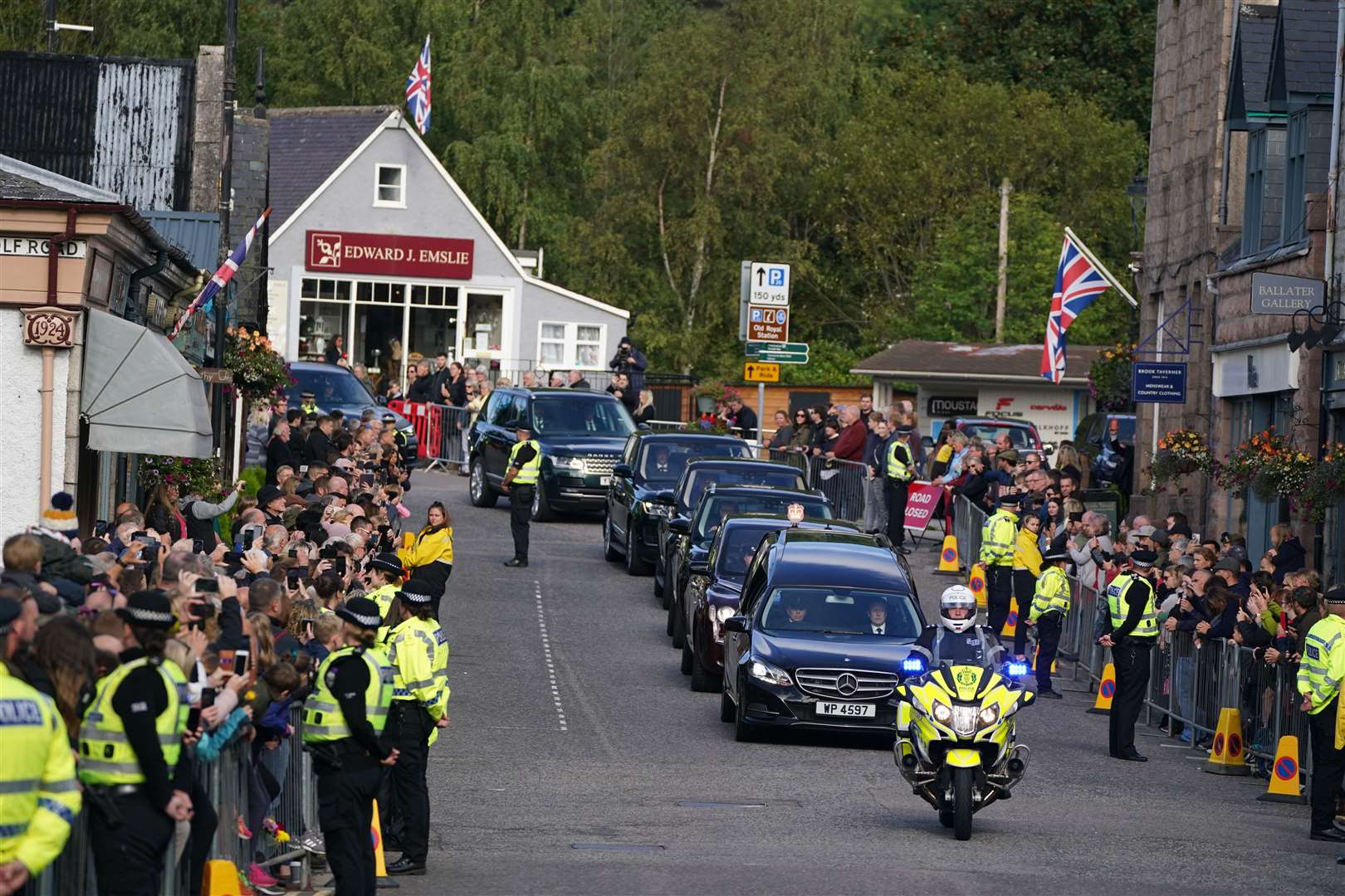 Hundreds of people lined the streets of Ballater as the hearse carried the Queen’s coffin through the town (Andrew Milligan/PA)