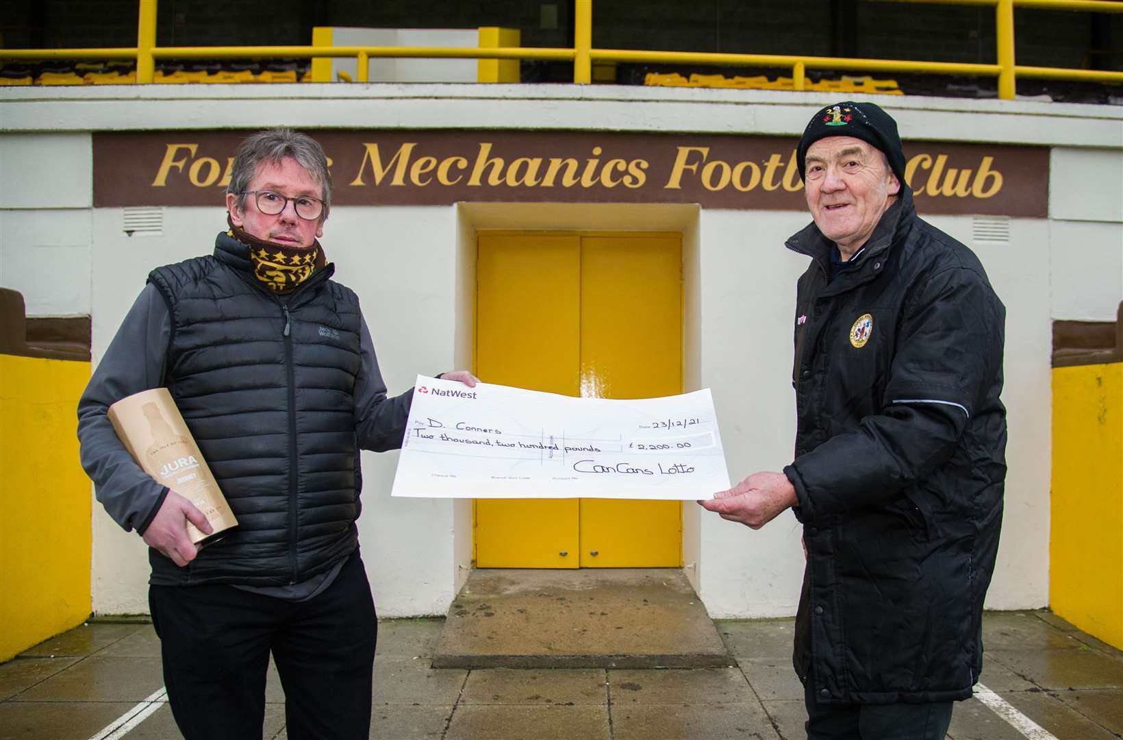 Dougie (right) is presented with a cheque by Cans vice-chairman George Alexander. Picture: Becky Saunderson