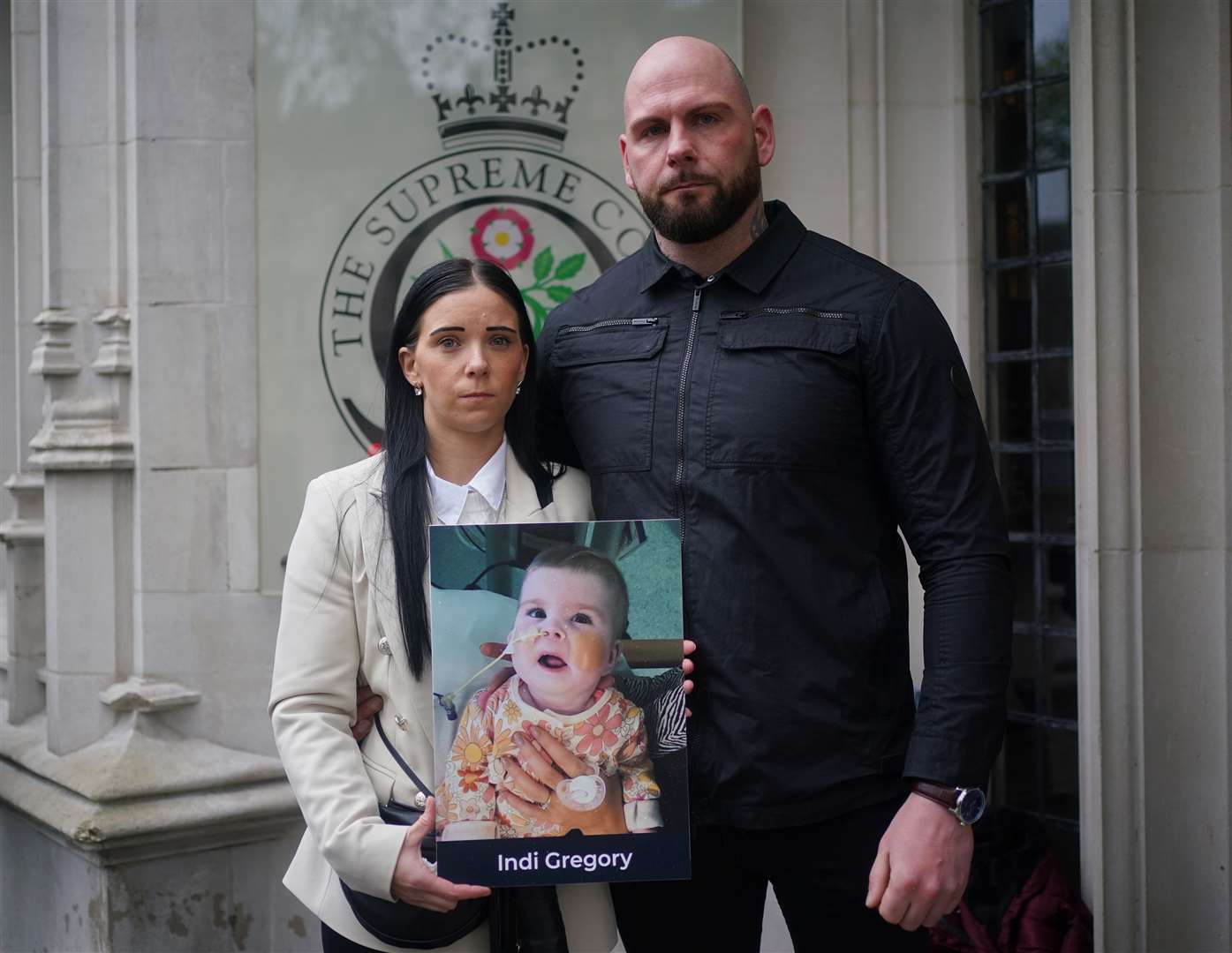 Dean Gregory and Claire Staniforth hold a photo of Indi Gregory (Yui Mok/PA)
