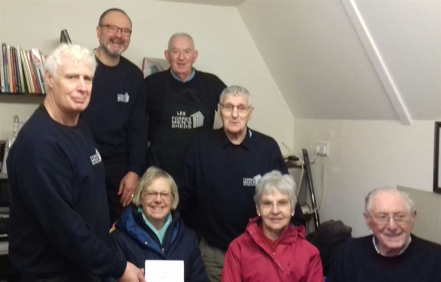 Forres Men’s Shed members (from left) Tony Hartley, Geoffrey Wilcock, Les Wilkinson, Davy Bell and Bill Valentine handling over a cheque to Forres McMillan Cancer Support treasurer Irene Manson and member Elspeth McKenzie.