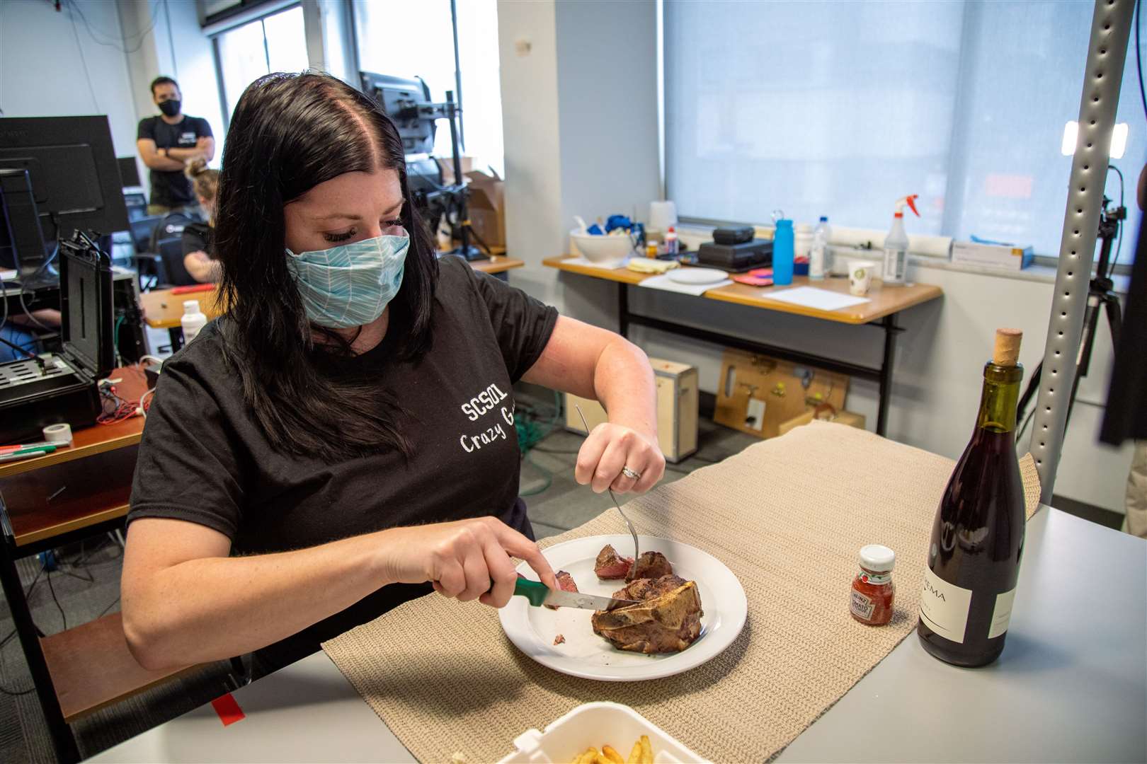 Heather Rendulic, who lost movement in her left arm after a stroke, was able to use a fork and knife to cut a piece of steak after spinal cord stimulation (Tim Betler/UPMC and University of Pittsburgh Schools of the Health Sciences)