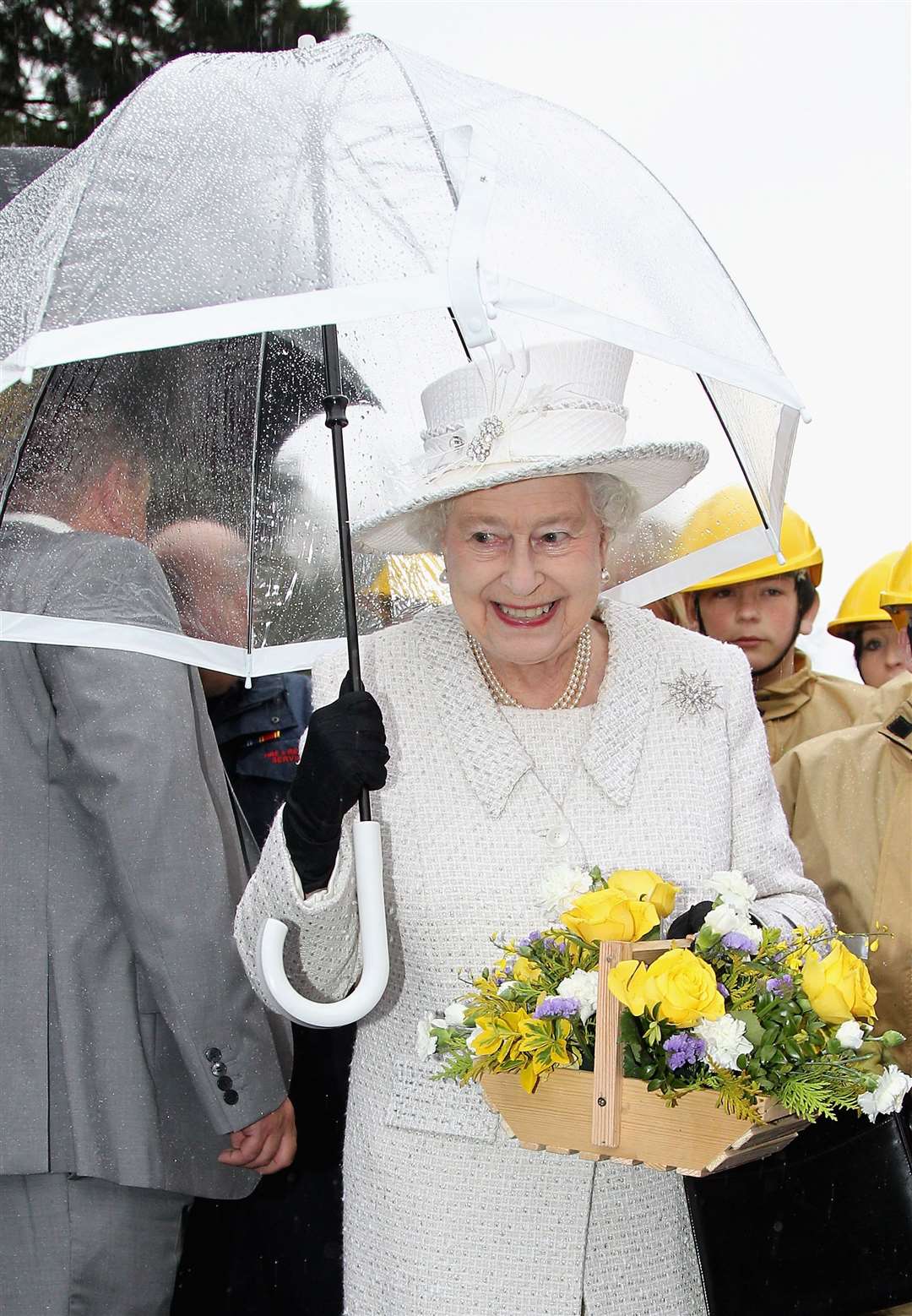 Queen Elizabeth II holds an umbrella during a rain shower on her visit to Cyfarthfa High School and Cyfarthfa Castle Museum in Merthyr during a visit to Wales as part of a UK-wide tour to celebrate her Diamond Jubilee (Chris Jackson/PA)