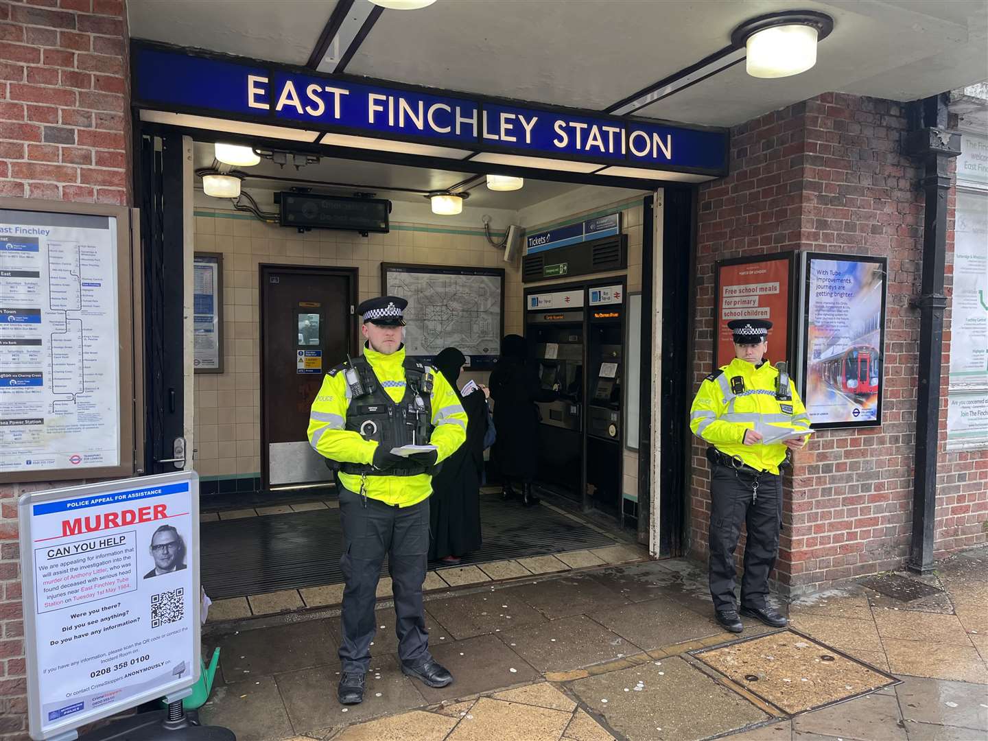 Metropolitan police officers by an appeal poster outside East Finchley Underground station in north London (Jamel Smith/PA)
