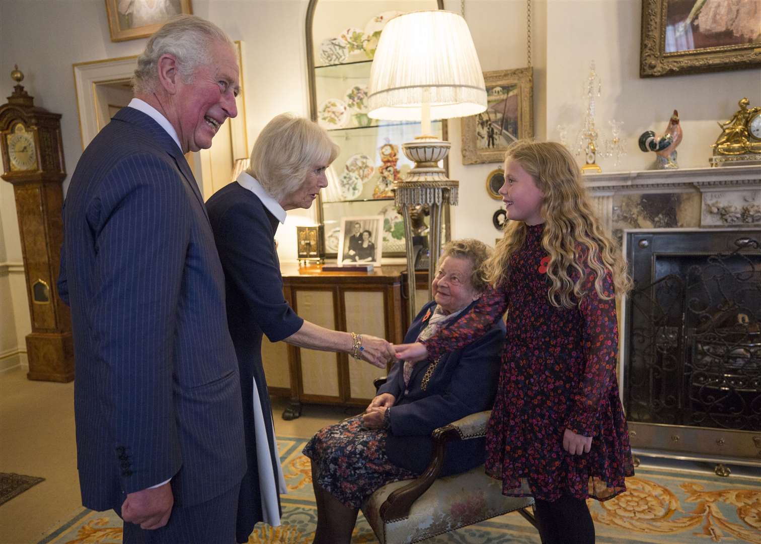 Poppy collectors Jill Gladwell, 95, and Maisie Mead, 10, meet Charles and Camilla (Victoria Jones/PA)