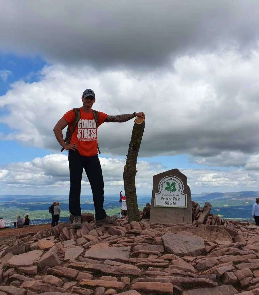 Jonathan Roberson at the top of Pen y Fan, carrying a log he trained with (Handout/PA)