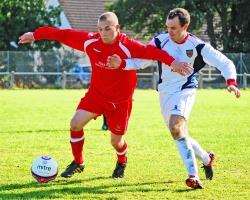 Forres player Alan Stacey keeps the ball from DAvid Christie