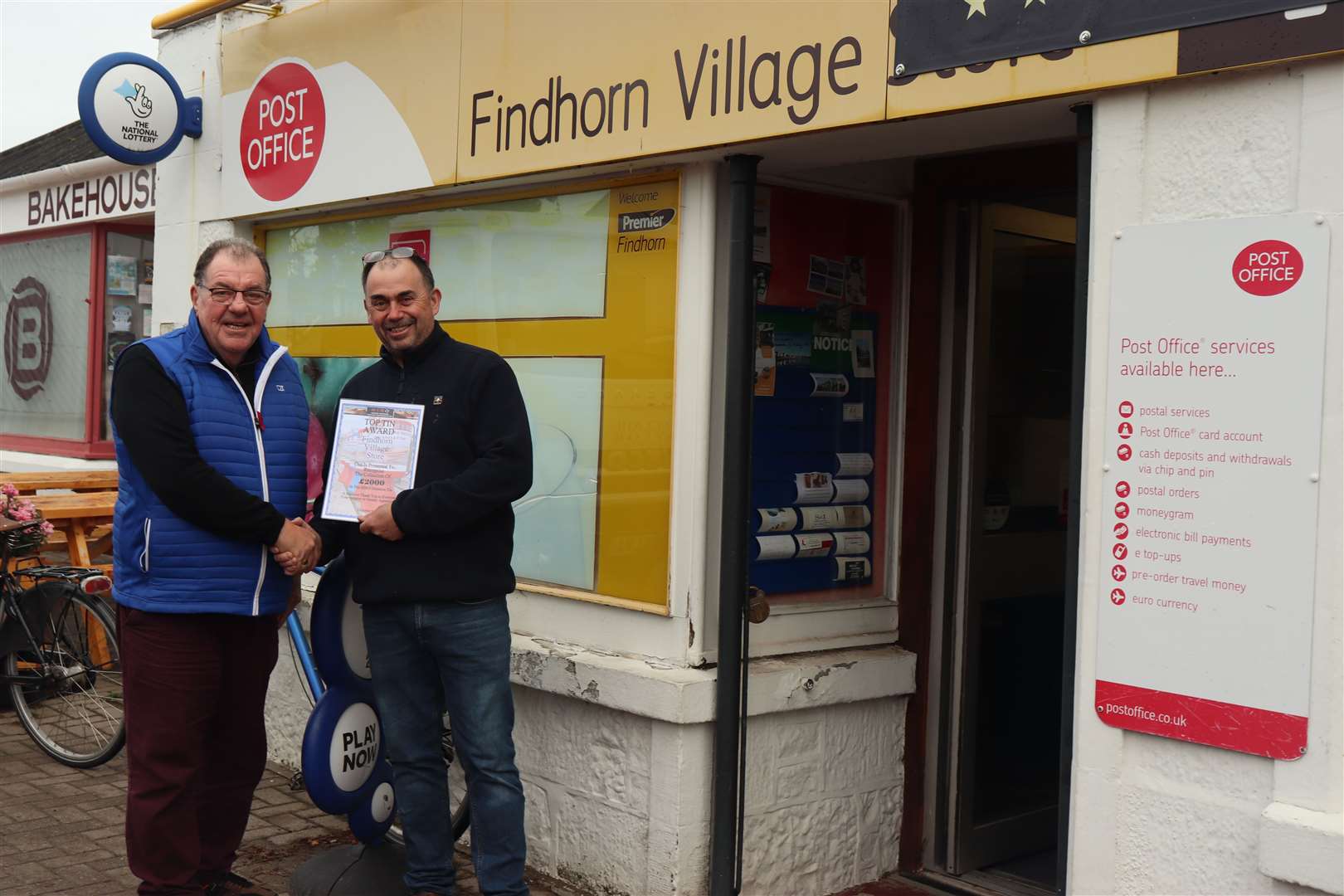 MIRO chairman John Low presenting Findhorn Village Store owner Richard Cross (right) with a certificate commemorating the fundraising feat.