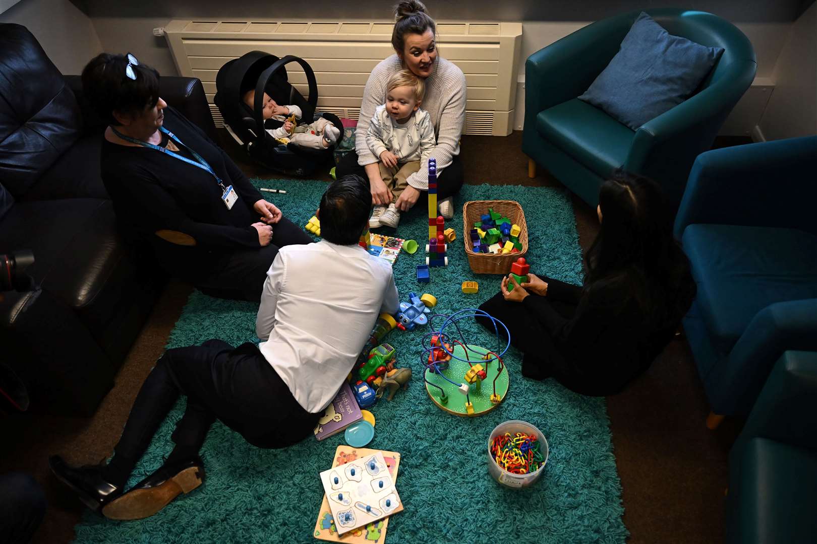 Prime Minister Rishi Sunak and his wife Akshata Murty (right) speak with Giselle, the mother of Seth, six months, and Brody, two, during the St Austell visit (Ben Stansall/PA)