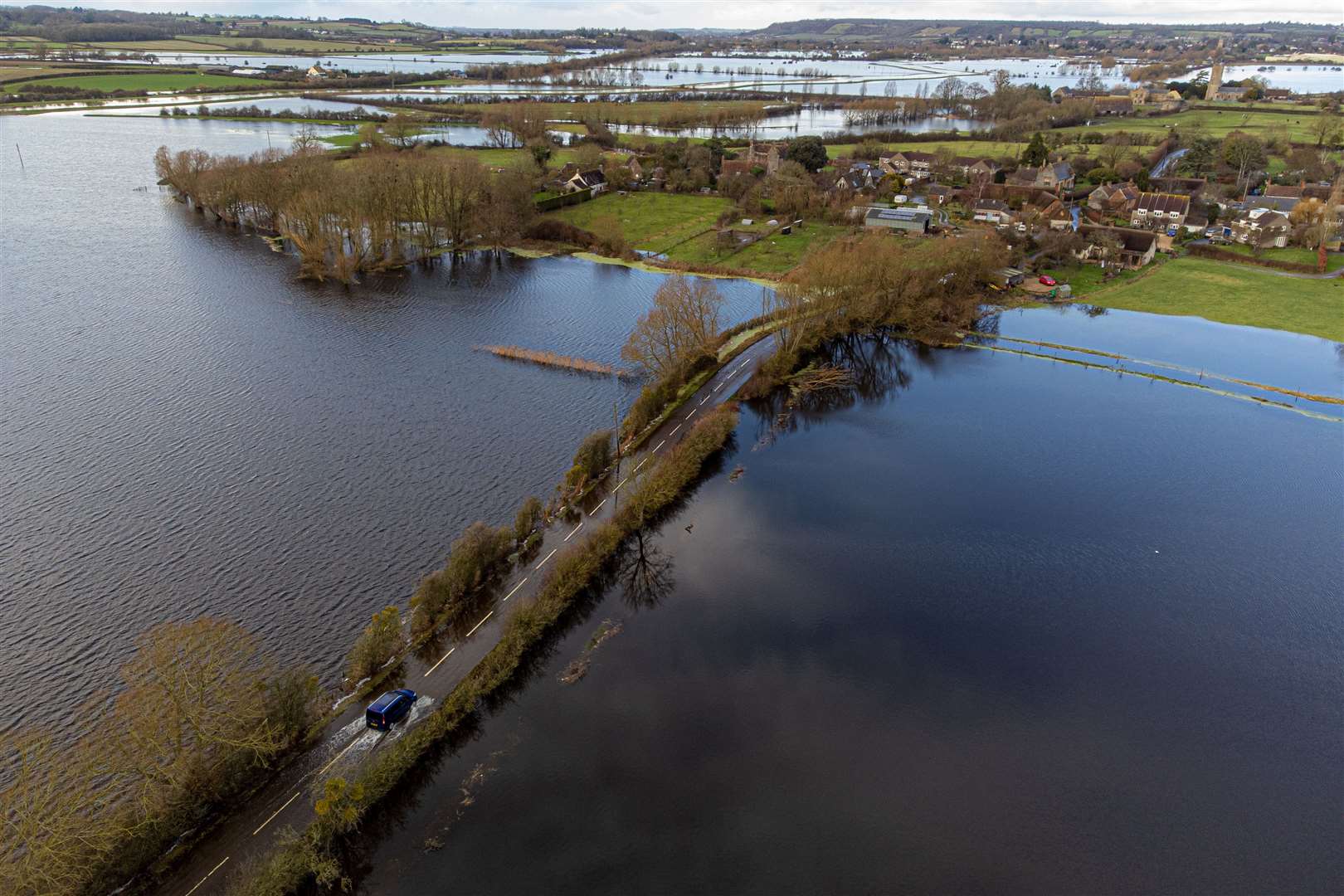 A car drives through floodwater near Muchelney, Somerset (Ben Birchall/PA)