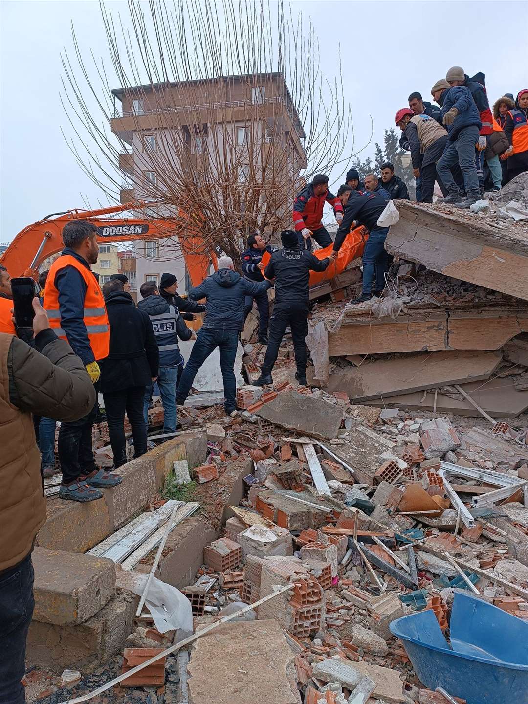 Police and volunteers removing a body from a collapsed building in Sanliurfa, Turkey (@mehmetyetim63/PA)
