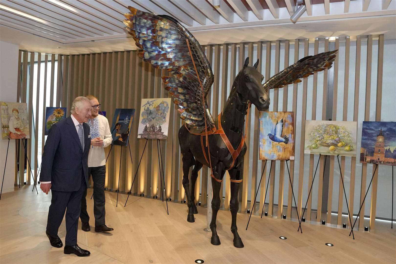 Charles walks through a display of artwork at the EBRD headquarters (Kirsty Wigglesworth/PA)