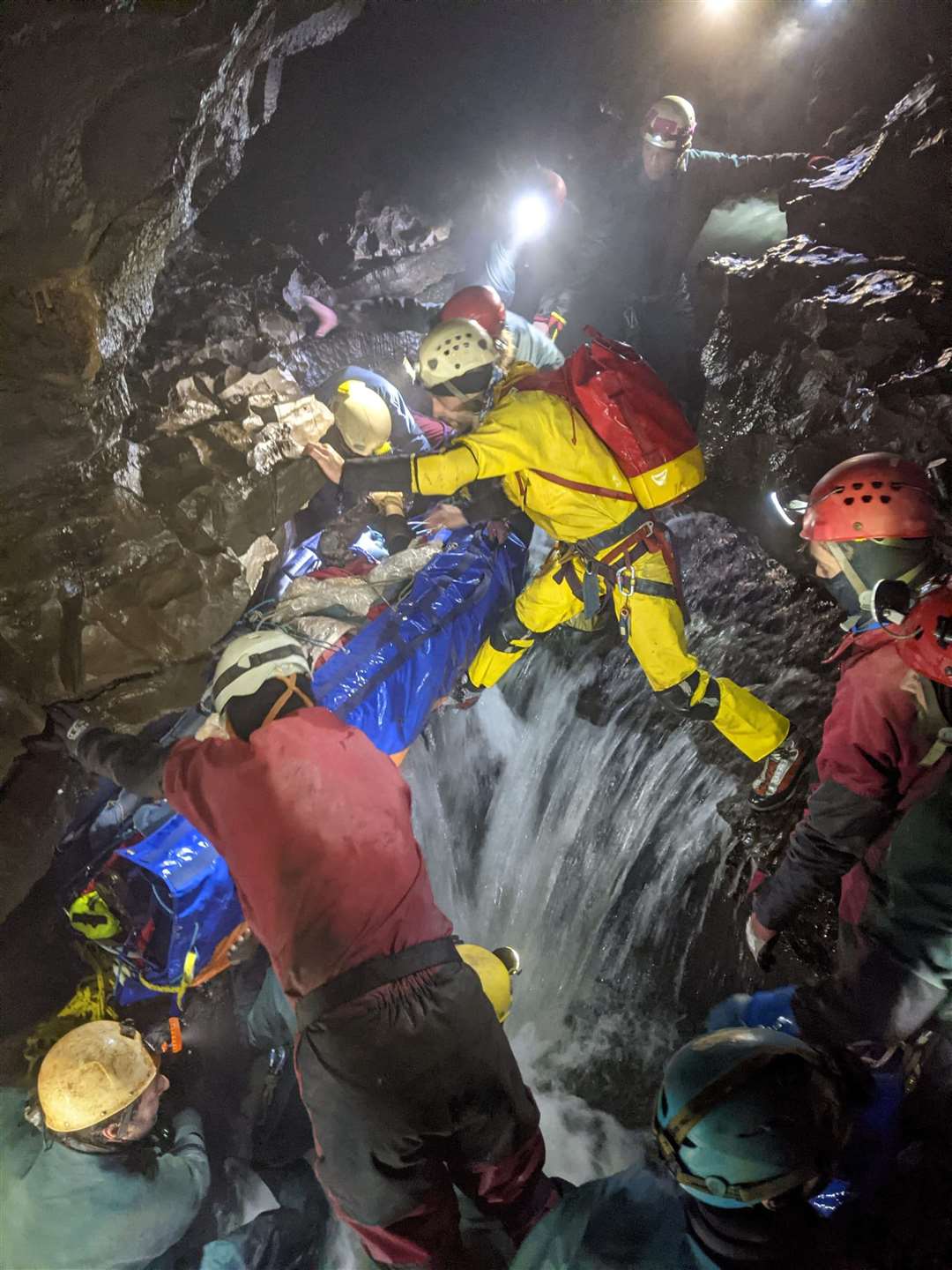The rescue team carrying Mr Linnane on a stretcher through a cave (South & Mid Wales Cave Rescue Team)