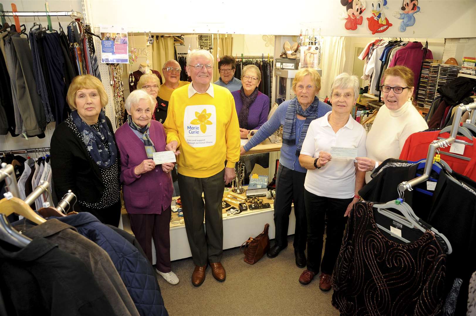 Picture: Eric Cormack. .Forres cancer support shop in town high st handed over Â£20,000 between marie curie and macmillan cancer support.longest serving volunteer jean mackenzie [2nd left] hands over a cheque to alan marshall of marie curie for Â£10,000 while sheila campbell hands over the same amount to elspeth mackenzie of macmillan cancer support.