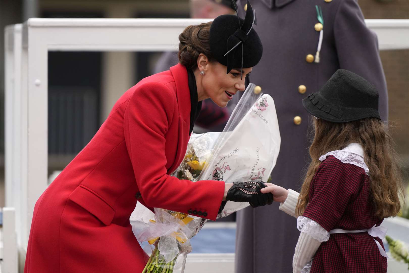 Kate is presented with flowers by a young girl in traditional Welsh costume (Alastair Grant/PA)