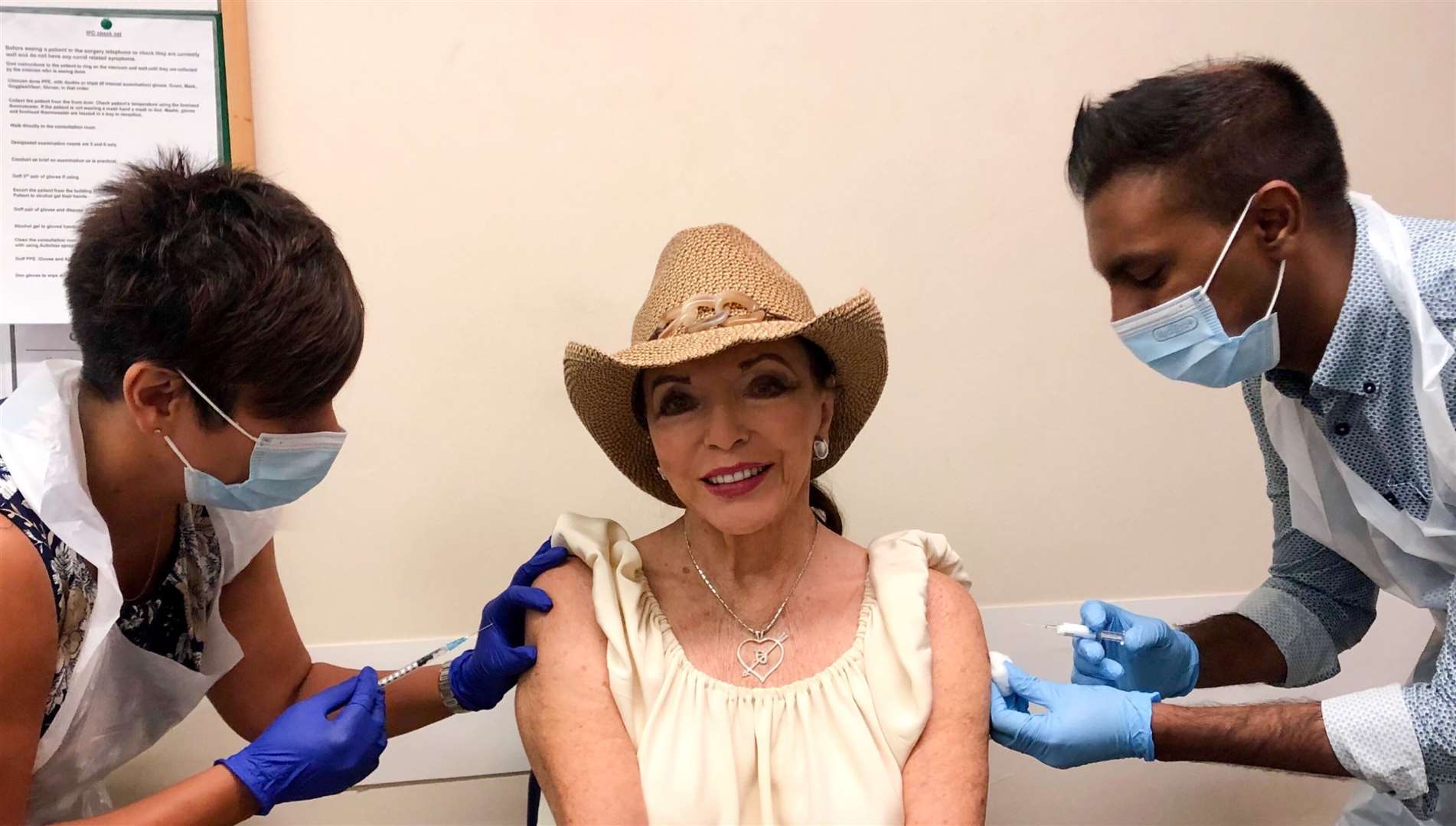 Dame Joan Collins receiving her coronavirus and flu jabs simultaneously last month (Percy Gibson/PA)