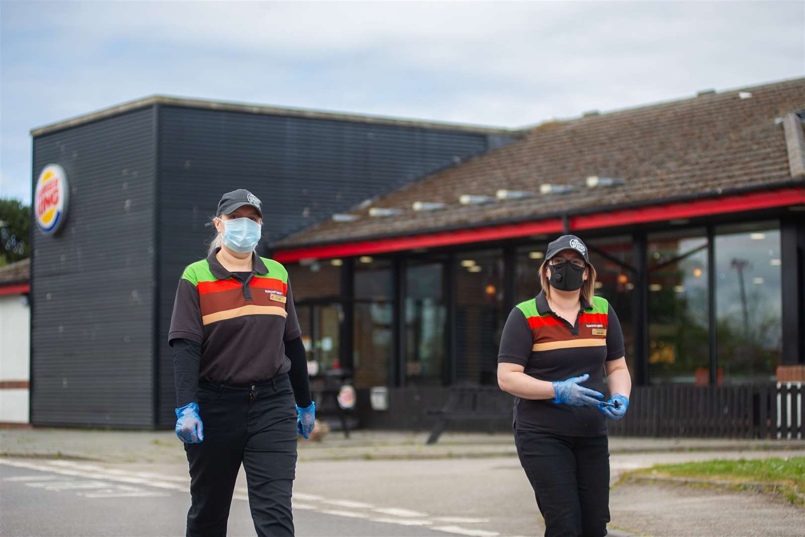 Staff members wear PPE as they inform customers of the delays. A large queue built up outside Burger King, Elgin, as the fast food chain was set to re-open after being closed due to the coronavirus pandemic. Picture: Daniel Forsyth.