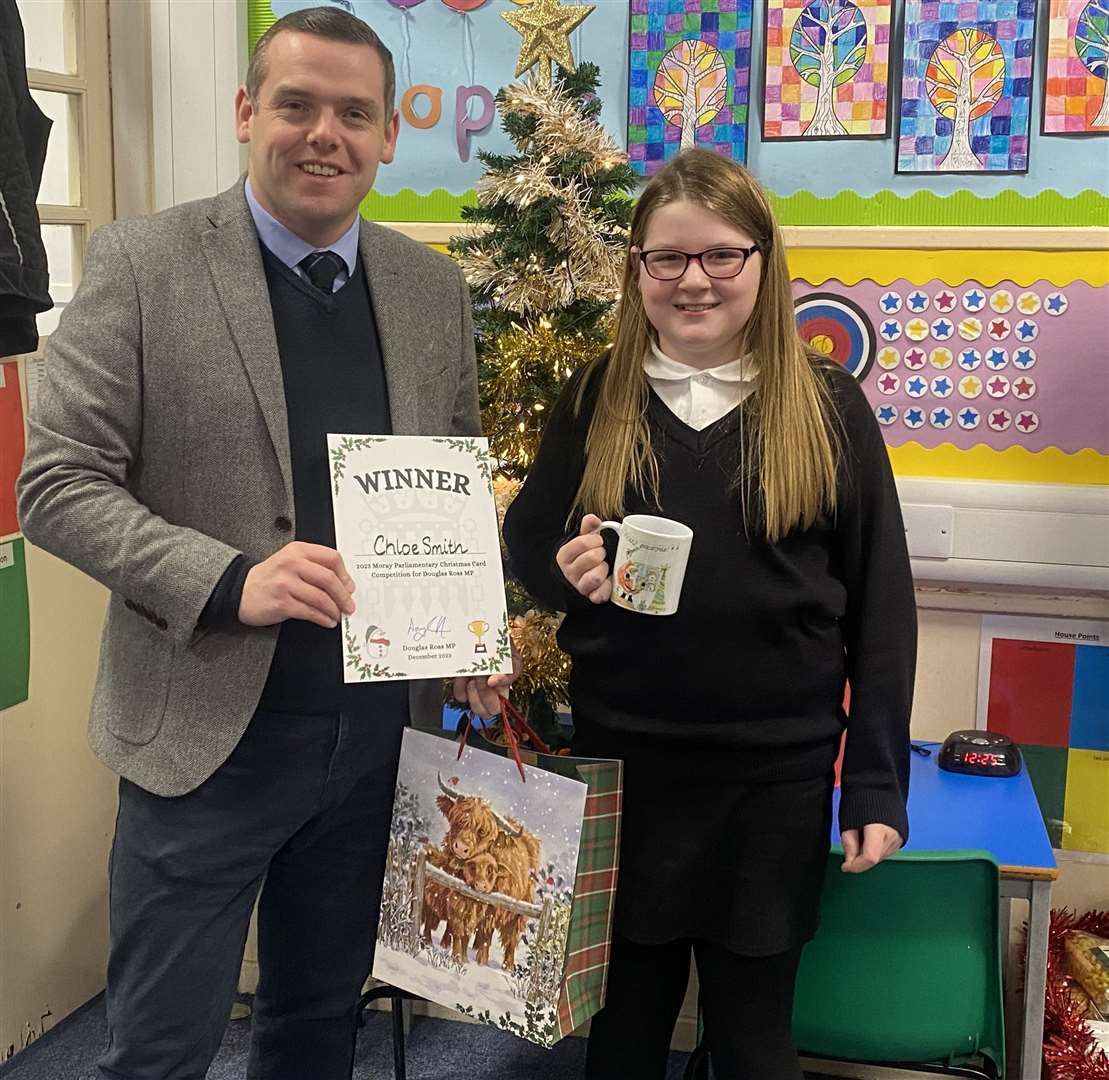 Moray MP Douglas Ross hands Cluny Primary pupil Chloe Smith her prizes after she won his Christmas card competition.